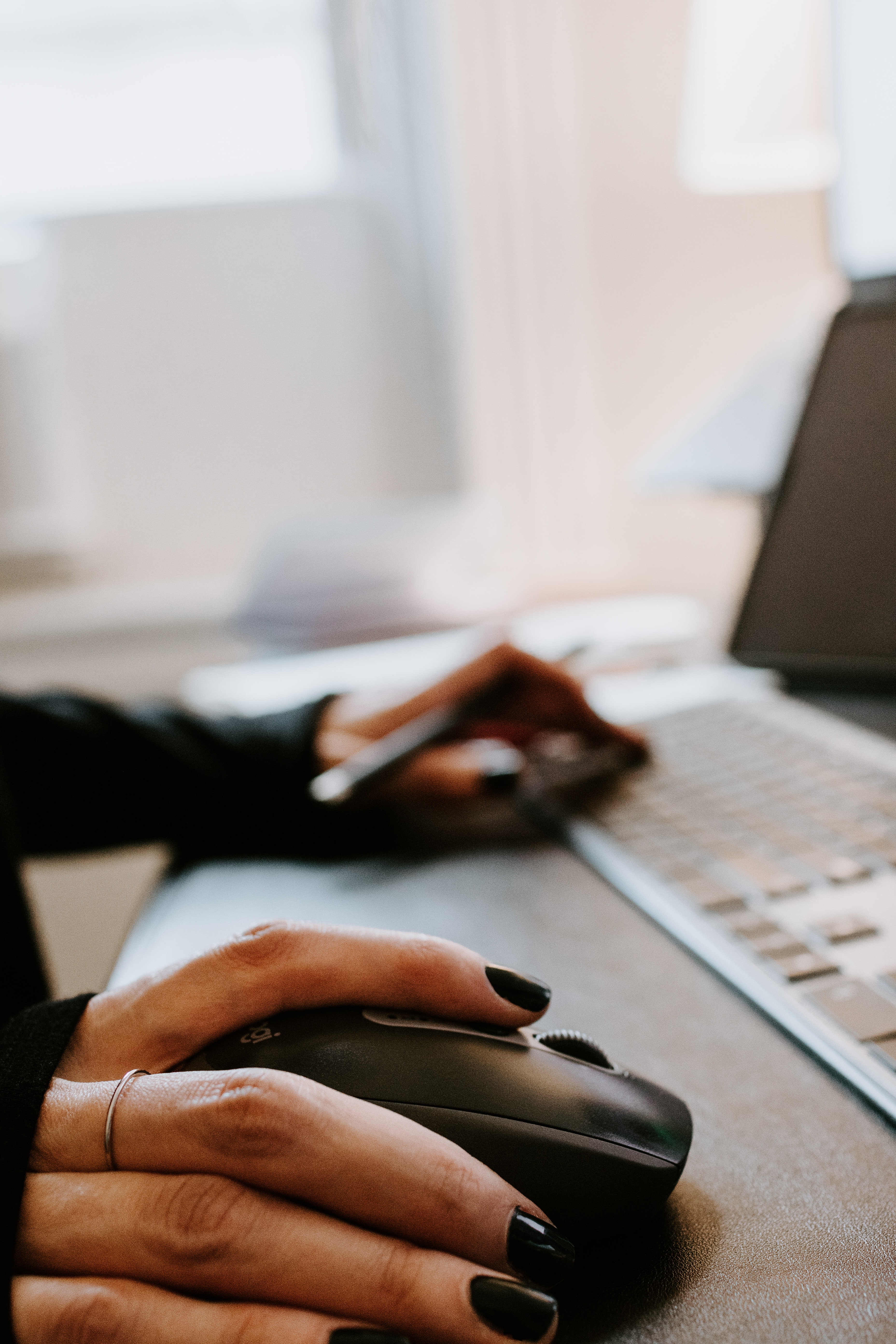 hand on a mouse at an office desk